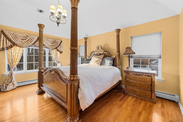 bedroom featuring multiple windows, baseboard heating, decorative columns, and visible vents