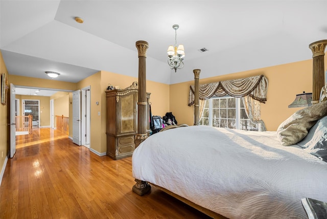 bedroom featuring a chandelier, light wood-style flooring, visible vents, baseboards, and vaulted ceiling