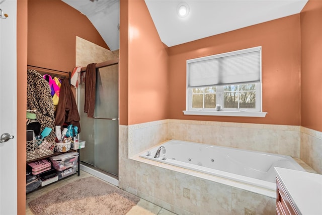 full bathroom featuring a jetted tub, a stall shower, tile patterned flooring, and vaulted ceiling