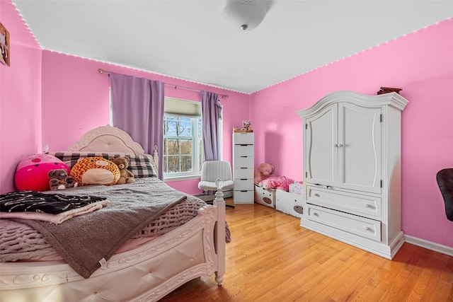 bedroom with light wood-style floors and baseboards