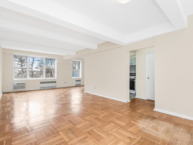 empty room with radiator, baseboards, and a wall mounted AC