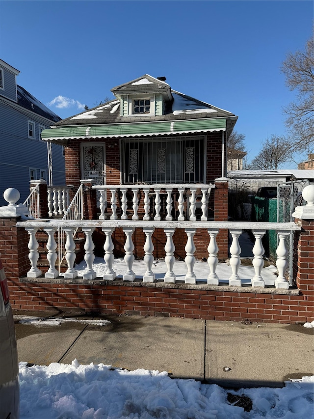 view of front of property featuring brick siding and a porch