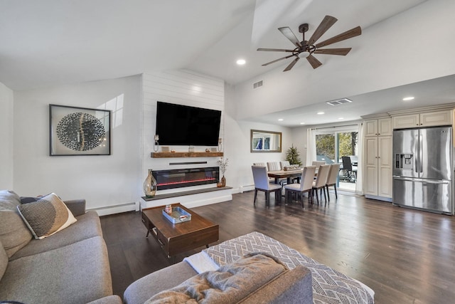 living room featuring lofted ceiling, visible vents, a glass covered fireplace, and a baseboard radiator