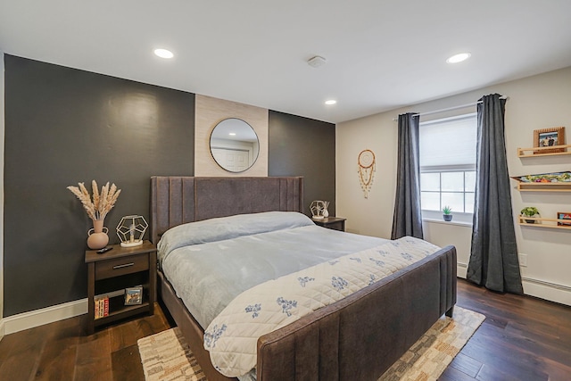 bedroom with dark wood-style floors, baseboard heating, recessed lighting, and baseboards