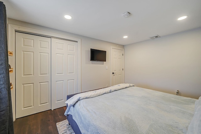 bedroom with a closet, visible vents, dark wood-style flooring, and recessed lighting