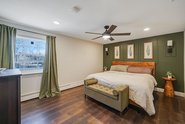 bedroom featuring baseboards, baseboard heating, and dark wood-style flooring