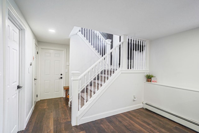 stairs with a baseboard radiator, wood finished floors, and baseboards