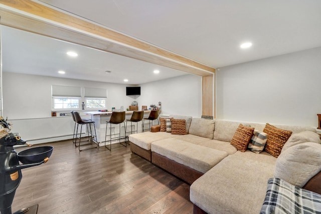 living room featuring recessed lighting, dark wood-style flooring, baseboard heating, and bar area