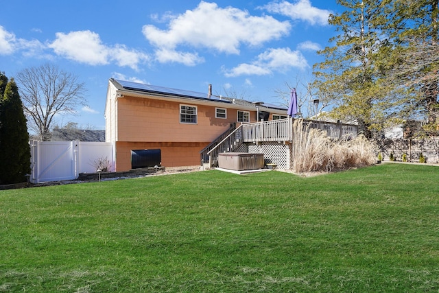 back of property featuring a yard, stairway, a wooden deck, and fence