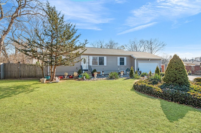 rear view of property featuring an attached garage, fence, and a lawn