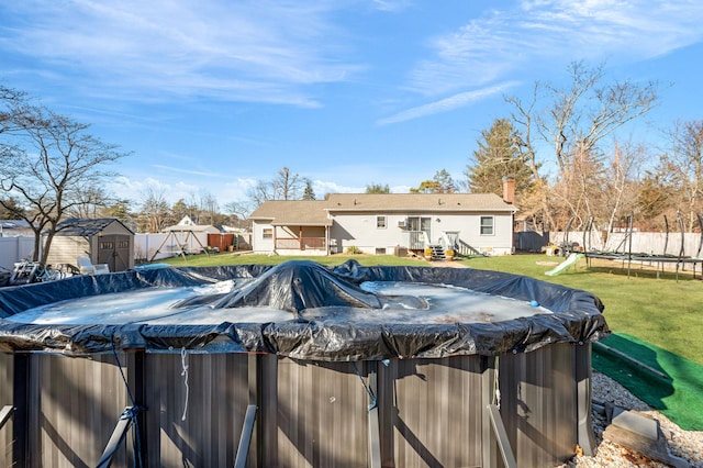 view of pool with a trampoline, a fenced in pool, entry steps, a shed, and an outdoor structure