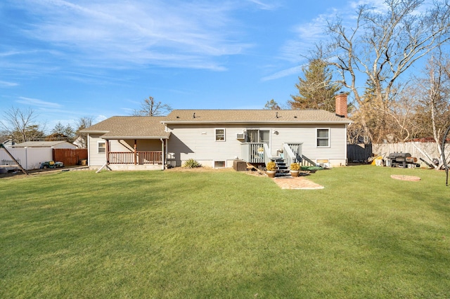 back of house with a fenced backyard, a chimney, and a yard