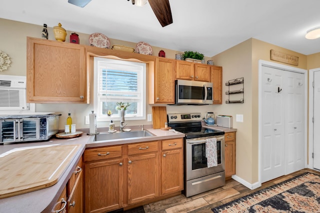 kitchen with a toaster, ceiling fan, appliances with stainless steel finishes, light countertops, and a sink