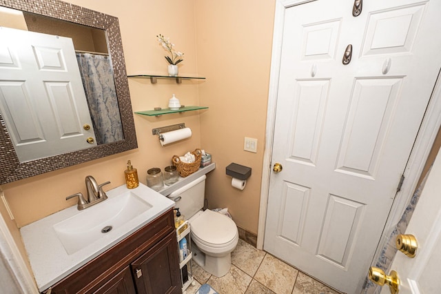 bathroom featuring toilet, vanity, and baseboards