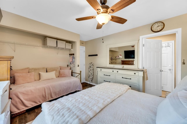 bedroom featuring ceiling fan, baseboards, and wood finished floors