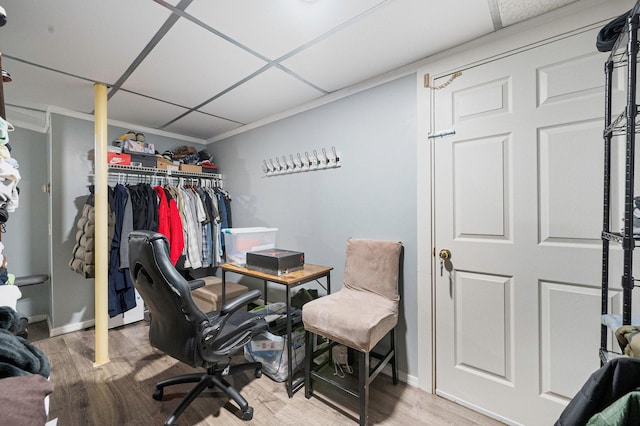 office space featuring a paneled ceiling, baseboards, and wood finished floors