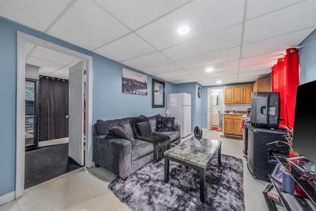 living room with a paneled ceiling and baseboards