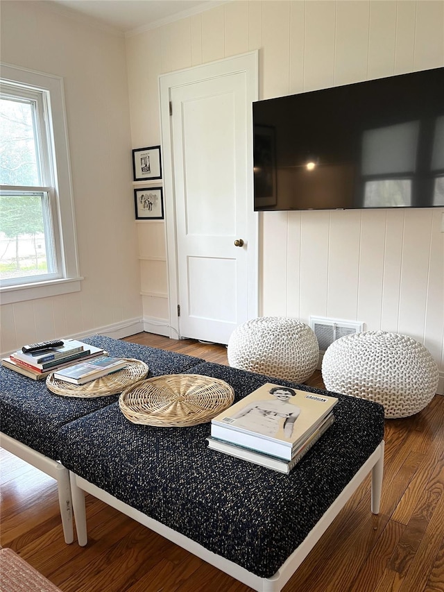 living area with crown molding and wood finished floors