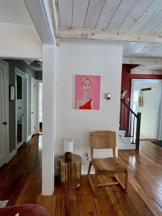 hallway with hardwood / wood-style flooring, baseboards, stairway, and beamed ceiling