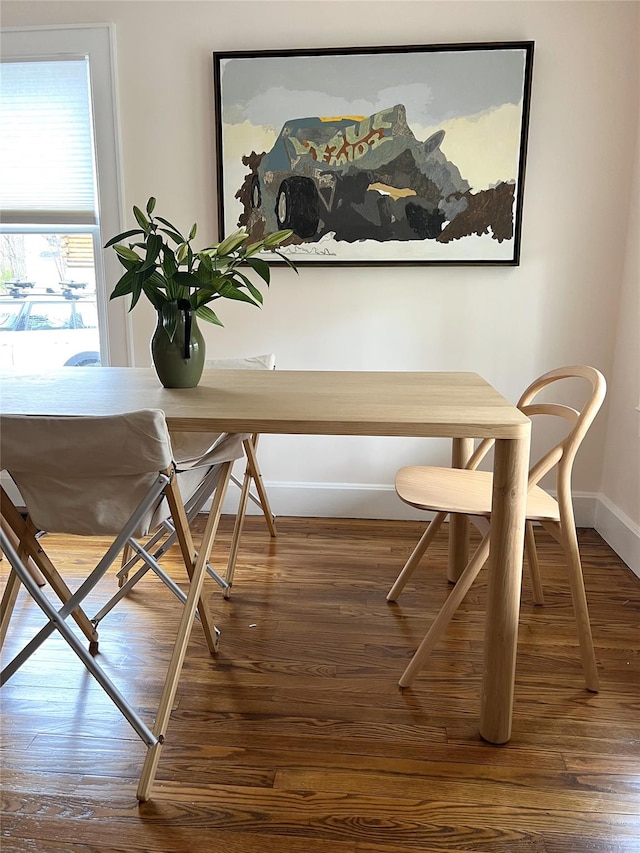 dining space with wood finished floors and baseboards