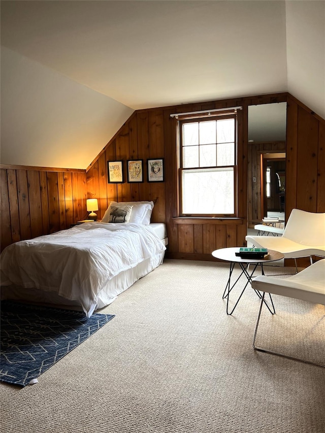 bedroom with vaulted ceiling, carpet, and wooden walls