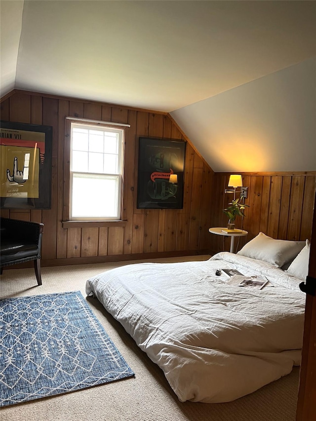 carpeted bedroom featuring lofted ceiling and wooden walls