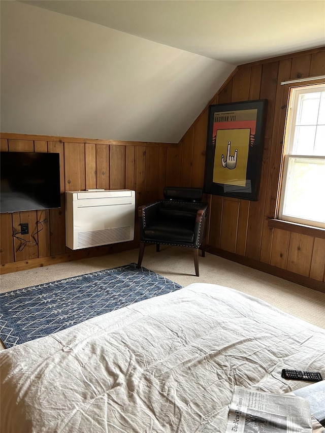 carpeted bedroom featuring lofted ceiling and wood walls