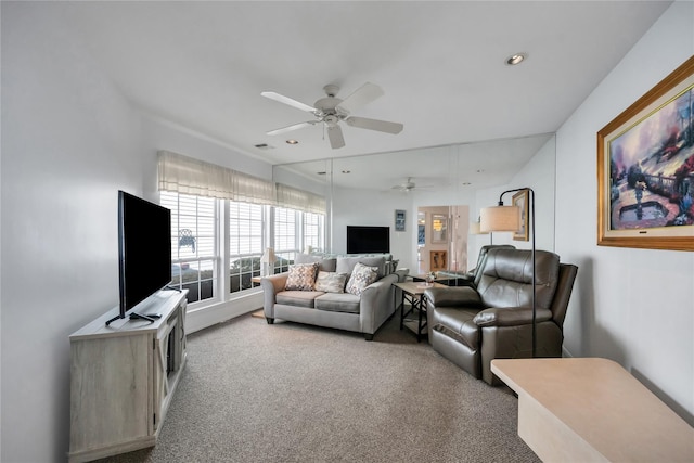 living area featuring light carpet, a ceiling fan, and recessed lighting