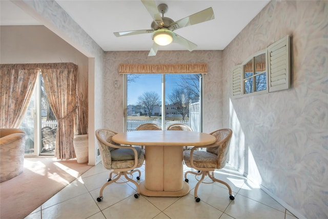 dining room featuring wallpapered walls, light tile patterned floors, and a ceiling fan