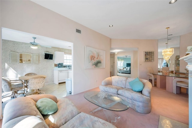 living area with light tile patterned floors, visible vents, light colored carpet, ceiling fan with notable chandelier, and recessed lighting