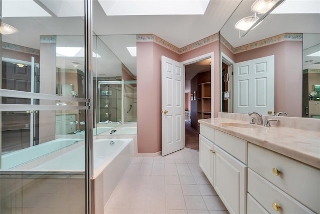 bathroom with a skylight, a stall shower, a garden tub, tile patterned flooring, and vanity