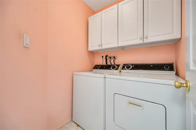 laundry room with cabinet space, light tile patterned floors, baseboards, and washing machine and clothes dryer