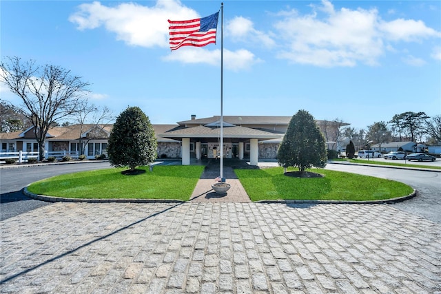 view of property's community with driveway, a lawn, and a residential view