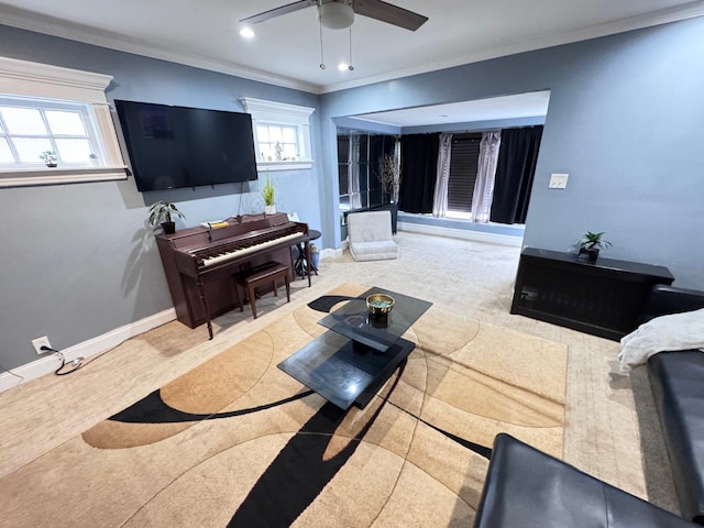 living area featuring ornamental molding, baseboards, and a ceiling fan