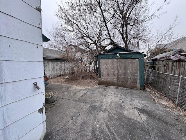 view of patio featuring a shed, a fenced backyard, and an outbuilding