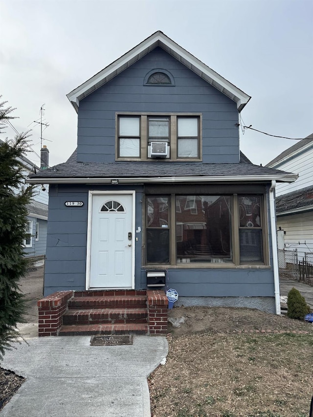 traditional-style home featuring entry steps, cooling unit, and roof with shingles