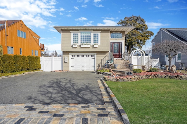 view of front of home with an attached garage, aphalt driveway, fence, and a front lawn