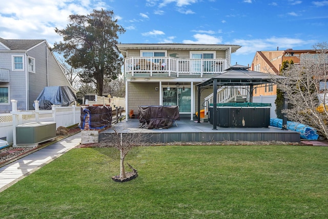 back of house featuring a gazebo, a yard, fence, and a hot tub