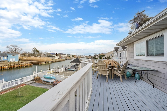 wooden deck featuring a water view, a residential view, and fence