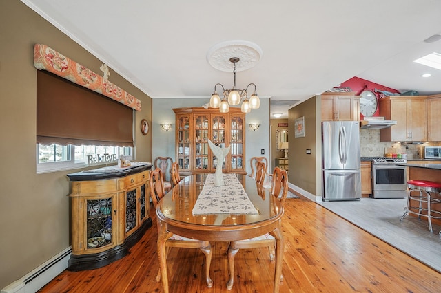 dining room with light wood-type flooring, a baseboard radiator, baseboards, and a notable chandelier