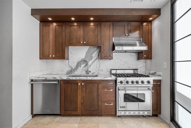 kitchen featuring appliances with stainless steel finishes, range hood, a sink, and light stone counters