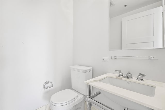 bathroom featuring toilet, visible vents, and a sink