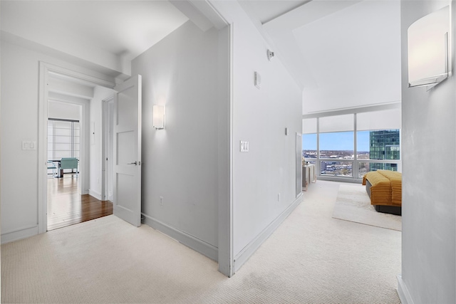 corridor featuring light carpet and baseboards