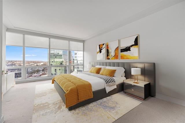 bedroom with expansive windows, baseboards, and light colored carpet