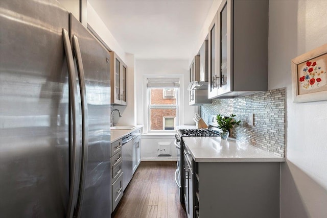 kitchen with tasteful backsplash, gray cabinets, stainless steel appliances, and light countertops