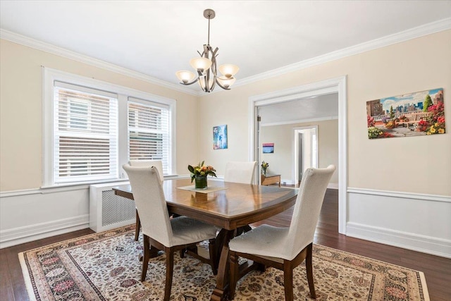 dining space featuring baseboards, a chandelier, crown molding, and wood finished floors