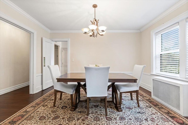 dining area with baseboards, radiator heating unit, wood finished floors, an inviting chandelier, and crown molding