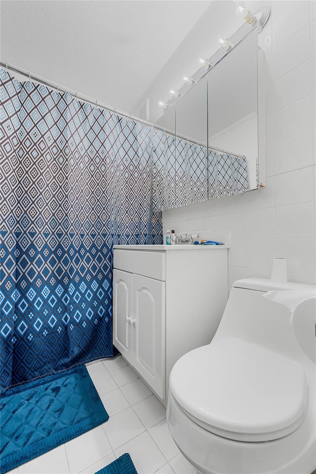 full bathroom with toilet, tile walls, and tile patterned floors