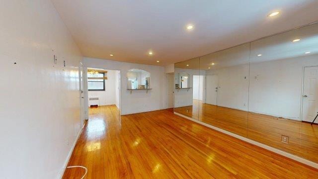 spare room featuring recessed lighting, radiator heating unit, and wood finished floors