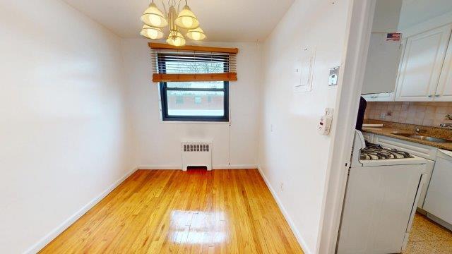 unfurnished dining area featuring baseboards, radiator, washer / clothes dryer, an inviting chandelier, and a sink